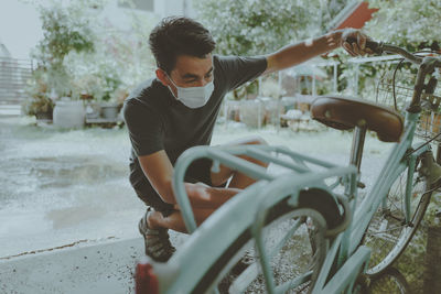 Young man checking his vintage bicycle