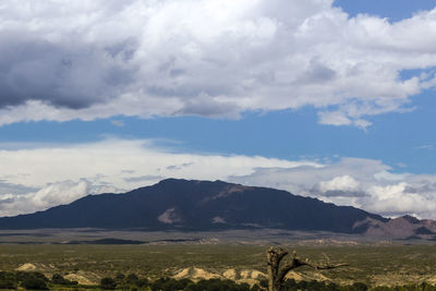 Scenic view of land and mountains against sky