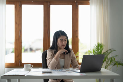 Young woman using laptop at office