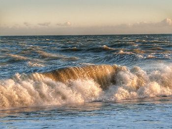 Sea waves rushing towards shore during sunset