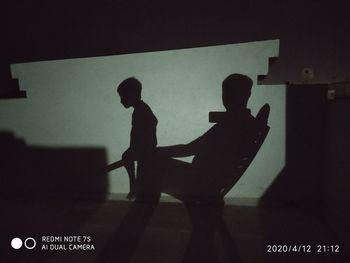 Shadow of man and woman sitting on table
