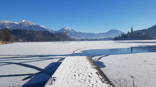 Scenic view of snowcapped mountains against clear blue sky