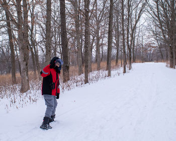 Full length of woman skiing on snow covered landscape