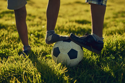 Low section of man playing soccer on field