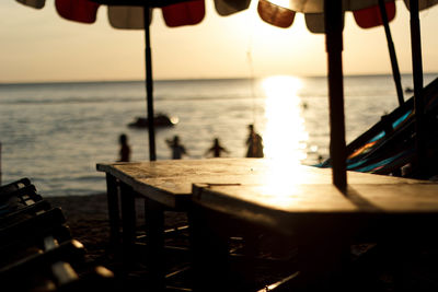 Chairs and table at beach against sky