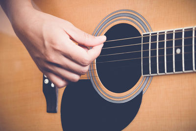 Cropped hand playing guitar