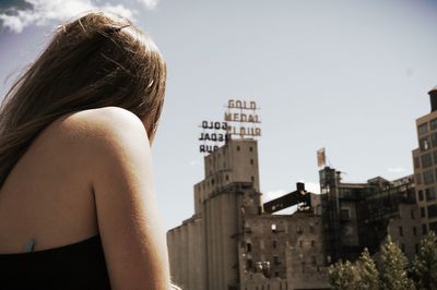 Rear view of woman looking away against buildings