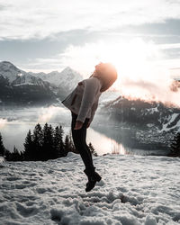 Full length of woman standing on snow covered mountain