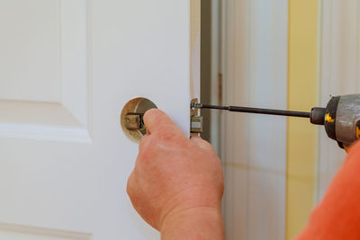 Cropped image of worker repairing door