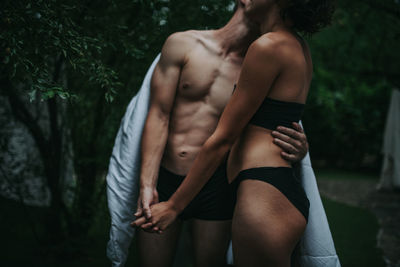 Midsection of woman standing against trees