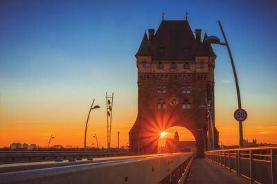 Road by bridge against sky during sunset