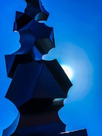 Low angle view of illuminated lamp against blue sky