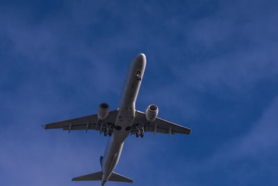 Low angle view of airplane flying against sky