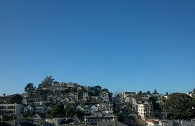 Buildings in city against blue sky