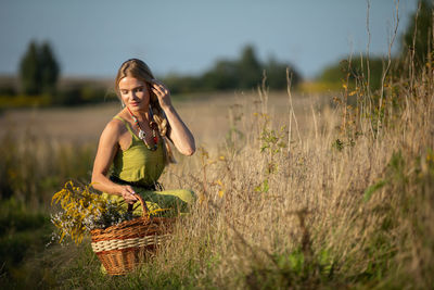 Portrait of young woman sitting on field