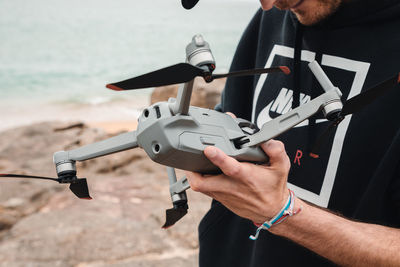 Cropped image of man holding drone