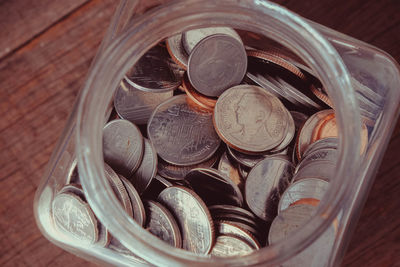 Close-up of coins in jar on table