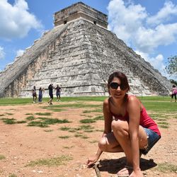 Full length of woman sitting on field against sky