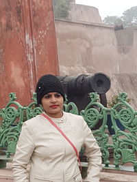 Portrait of young man standing against built structure