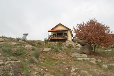 House amidst trees and buildings against sky