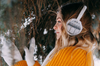 Teen blonde in a yellow sweater outside in winter. a teenage girl on a walk in winter clothes