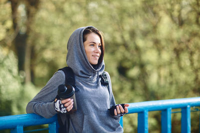 A brunette girl in a hoodie in nature walks in the park in autumn weather.