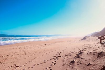 Scenic view of beach against blue sky