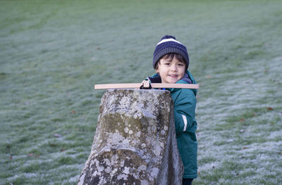 Portrait of smiling boy wearing warm clothing playing in park