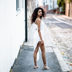 Portrait of young woman standing on footpath