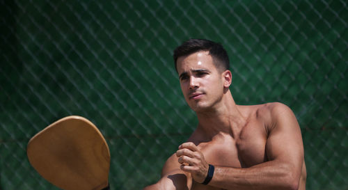 Shirtless young man with sports equipment