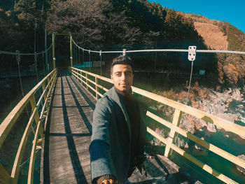 Portrait of young man on footbridge