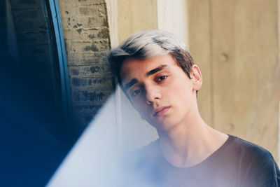 Portrait of young man against wall