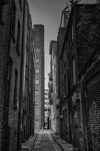 Narrow alley amidst buildings in city against sky