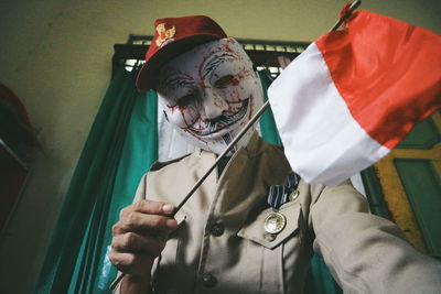 Man wearing mask holding indonesian flag