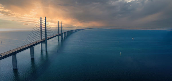 Bridge over sea against sky during sunset