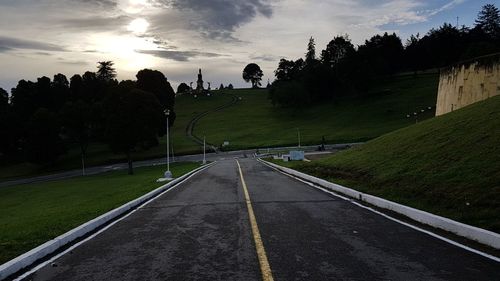 Road amidst trees against sky