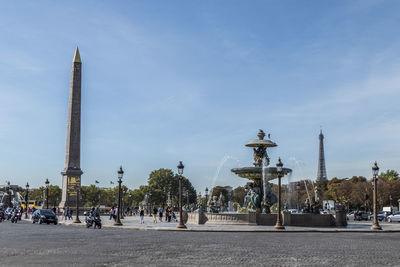  place de la concorde in paris with an obelisk and fountain and the eiffel tower in background