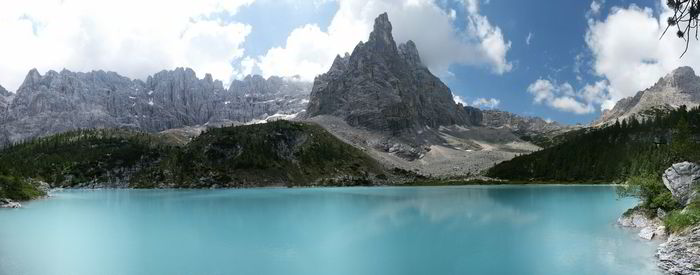 Scenic view of lake and mountains against cloudy sky