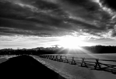 Empty road against cloudy sky