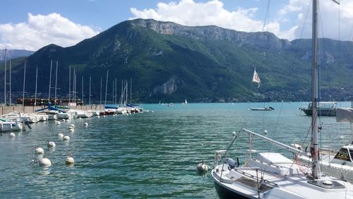 Sailboats moored on sea against sky