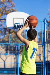 Boy playing basketball in court