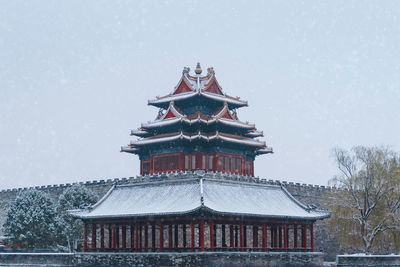 Low angle view of traditional building against sky during winter