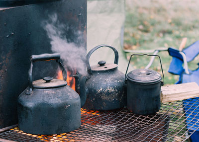 Close-up of rusty metal container on wood burning stove