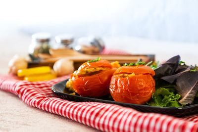 Close-up of stuffed tomatoes with salad in plate on table