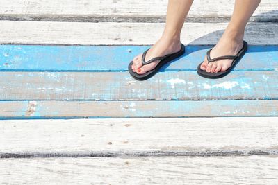 Low section of woman wearing high heels on swimming pool