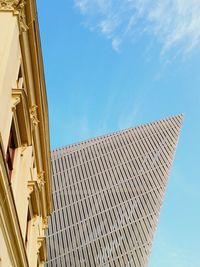 Low angle view of modern building against blue sky