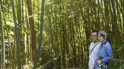 Portrait of young woman standing in forest