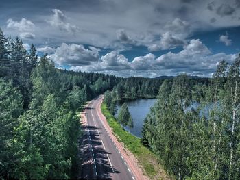 Panoramic view of road along plants and trees against sky