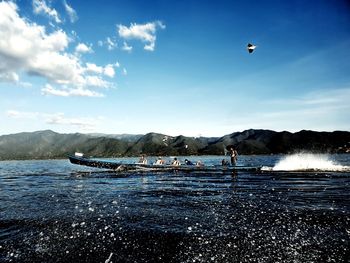 People flying over sea against sky