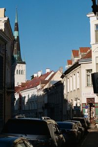 Cars in town against clear sky